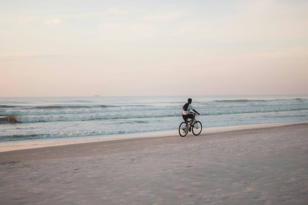 Man riding a bike near the water